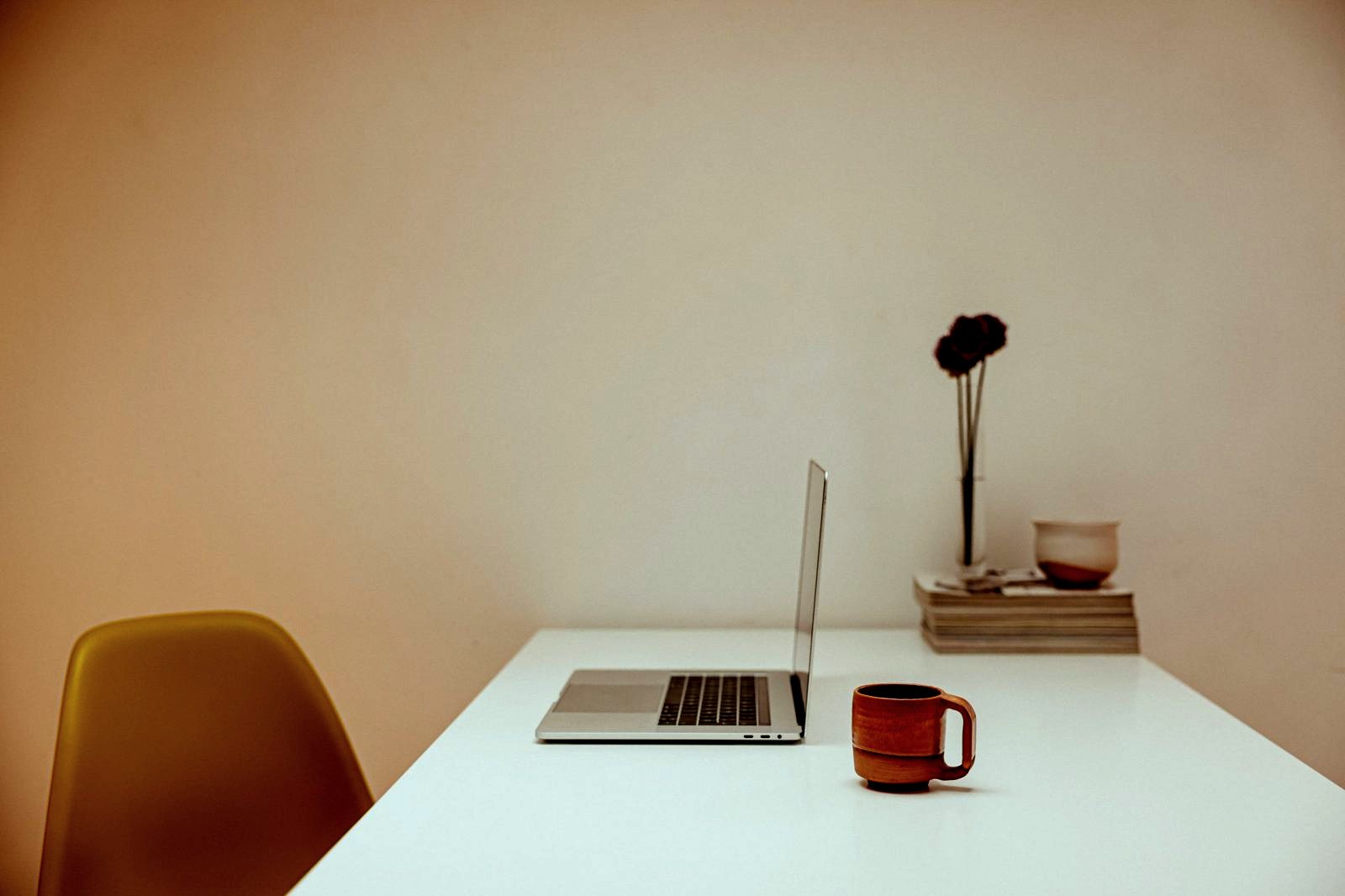 A bright desk with a laptop and a cup