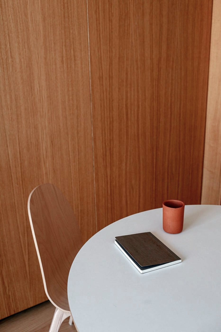 A quiet meeting table with a notebook and a cup
